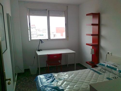 布尔哈索特PISO CON VISTAS的一间卧室配有一张床、一张书桌和一个窗户。
