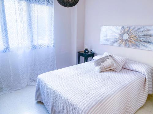 圣费尔南多El rinconcito de la Isla的白色的卧室设有床和窗户