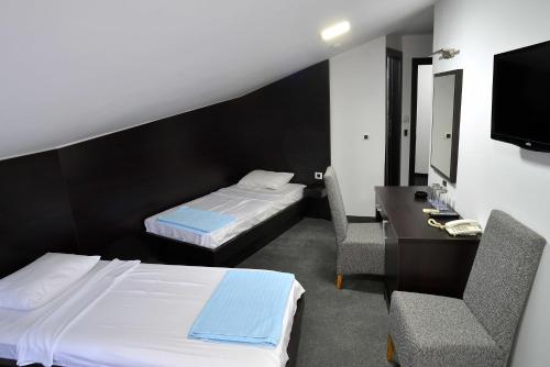 克鲁舍瓦茨高尔夫酒店的酒店客房设有两张床、一张桌子和一台电视。