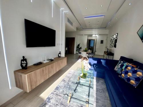 蓬塔卡纳Relax Apto Pool and Golf View in Hard Rock Golf的客厅配有蓝色的沙发和平面电视。