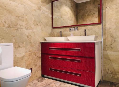 塞尼塞罗Villa turística Camina y Rioja的一间带红色橱柜和水槽的浴室