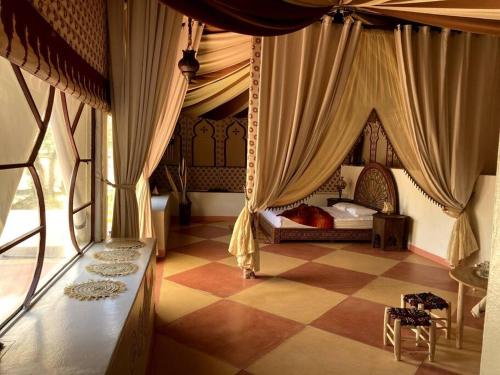 HeddadTente du Borj Zarraba的一间卧室配有一张带窗帘的床和 ⁇ 形地板