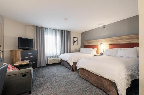 梅里尔维尔梅里维尔烛木套房酒店的酒店客房设有两张床和一台平面电视。