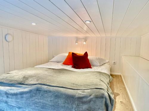 StenhamraOrres Guesthouse Stenhamra, Ekerö的一间卧室配有一张带两个红色枕头的床
