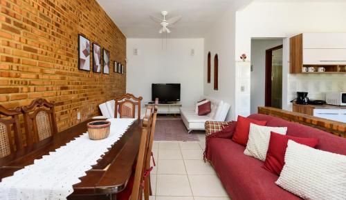 萨夸雷马Village Itaúna Inn的客厅设有红色沙发和砖墙