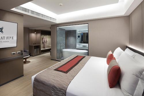 曼谷Grace At Five by Grace Hotel Bangkok的一间带大床的卧室和一间浴室