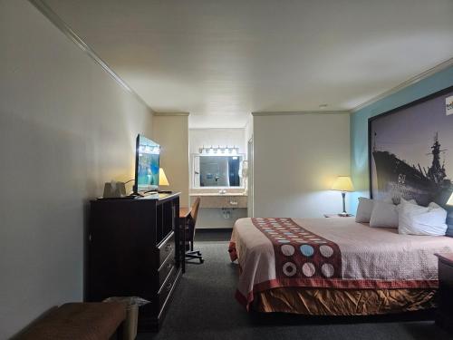 Moodybudgetel Inn & Suites的配有一张床和一台平面电视的酒店客房