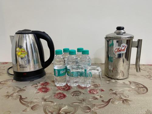 阿姆利则Homestay Comforts 500m from Amritsar Airport的咖啡壶旁的一组瓶装水