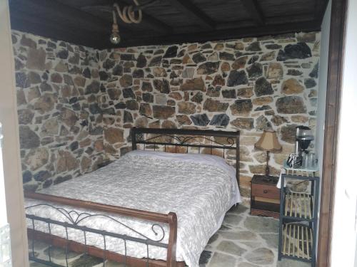 霍里顿Ελαιώνας - Solar Energy House的卧室配有一张石墙床