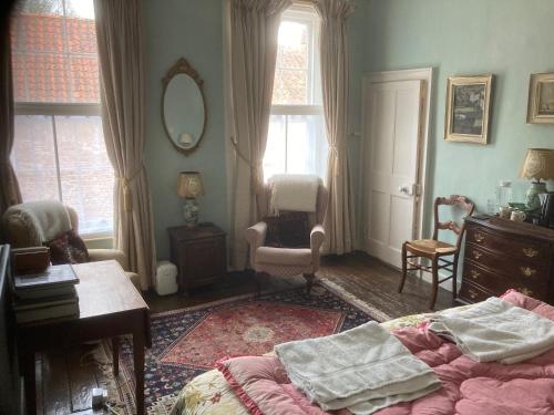 小沃尔辛厄姆The Old Bakehouse, Walsingham的一间卧室配有一张床、一把椅子和镜子