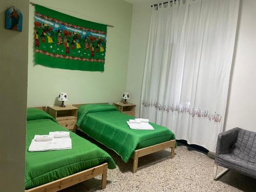 卡塔尼亚Beteyà Hostel Don Bosco的一间设有两张绿色床和旗帜的房间