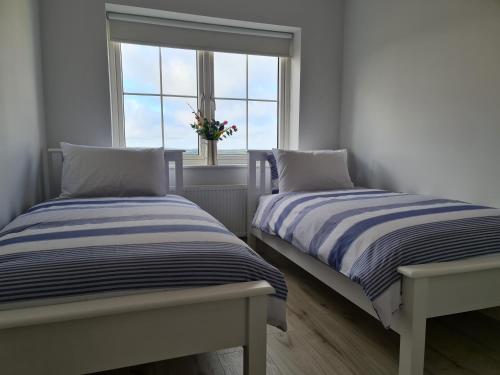 金塞尔Abbeyfort Kinsale的带窗户的客房内的两张床