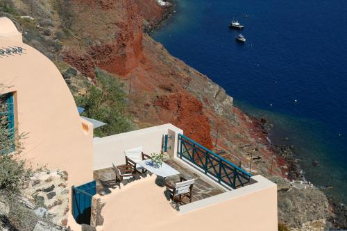 伊亚Oia VineyART Homes的悬崖边的餐厅,俯瞰着大海