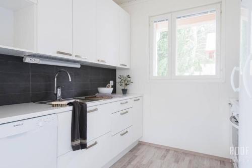 赫尔辛基100m2 moderni paritalo omalla pihalla Helsingissa的白色的厨房设有水槽和窗户