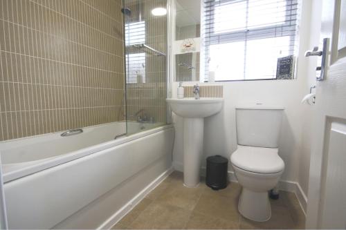 朗伊顿4ft Double bed with Parking & Wi-fi in Modern Townhouse in Long Eaton的浴室配有卫生间、浴缸和水槽。