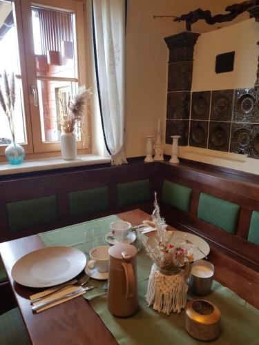 绍萨尔地区基策克Weingut Reiterer的一间用餐室,配有带盘子和杯子的桌子