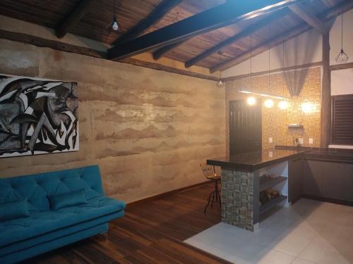 卡瓦坎特Villa Taipas - Chalé Iepê的客厅配有蓝色的沙发和桌子