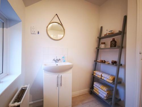 康威Rose Cottage的浴室设有水槽和墙上的镜子
