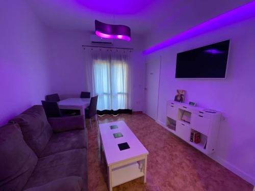 科尔多瓦COSTASOL CORDOBA - Apartamento moderno - céntrico的客厅配有沙发、桌子和紫色灯