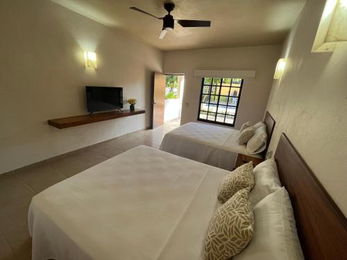 锡瓦塔塔内霍Natura Hotel & Villas的一间卧室配有两张床和一台平面电视