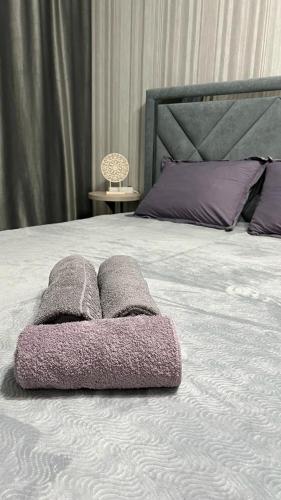 库斯塔奈Комфортабельные - уютные апартаменты в Костанай мкр Береке1的床上有一堆毛巾