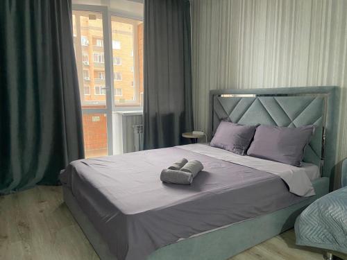 库斯塔奈Комфортабельные - уютные апартаменты в Костанай мкр Береке1的一间卧室配有一张床,上面有两条毛巾