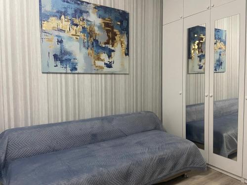 库斯塔奈Комфортабельные - уютные апартаменты в Костанай мкр Береке1的卧室配有一张床,墙上挂有绘画作品