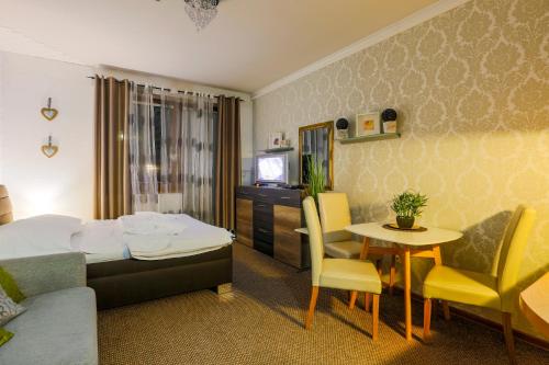 鲁容贝罗克Apartmánový dom Fatrapark 1 s Wellness - Hlavná recepcia的酒店客房带一张床、一张桌子和椅子
