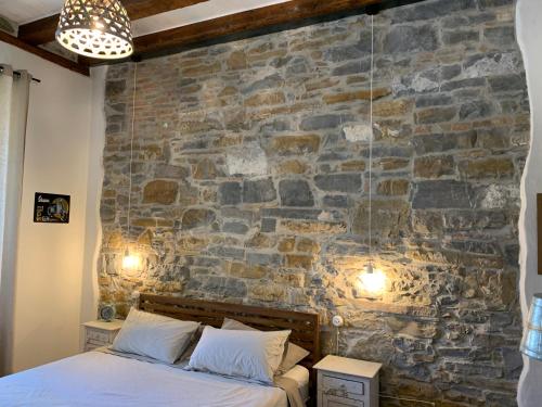 的里雅斯特Santorio 5 Apartment的一间卧室设有石墙和一张床