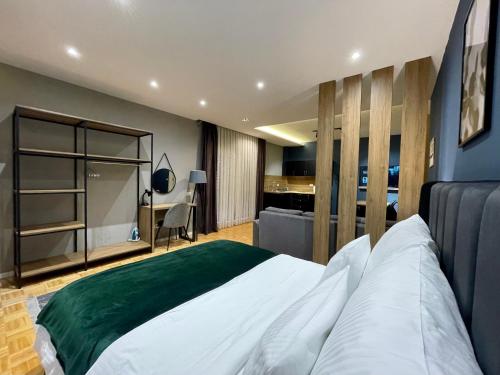 GjakovePremium Apartments的卧室配有一张白色大床和一张书桌
