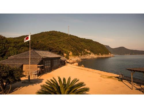 IkedaKokuminshukusha Shodoshima - Vacation STAY 59358v的水体旁建筑物上的旗帜