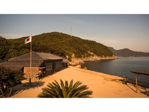 IkedaKokuminshukusha Shodoshima - Vacation STAY 59365v的水体旁建筑物上的旗帜