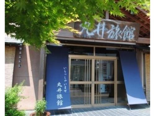 新发田市Hotel Marui - Vacation STAY 99286v的一座建筑,上面有蓝色的门和标志