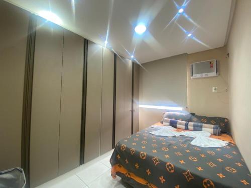 马瑙斯Apartamento Ideal Flores的一间卧室配有一张床,天花板上灯火通明
