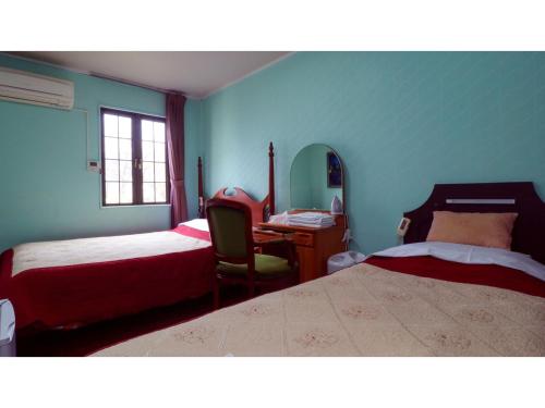 日光Nikko Park Lodge - Vacation STAY 15302v的一间卧室配有两张床、一张桌子和一把椅子