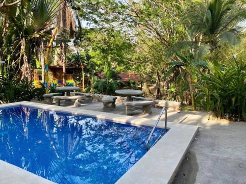 萨玛拉Sámara Tarantela Houses, Casa Bambú的庭院内带野餐桌和长凳的游泳池