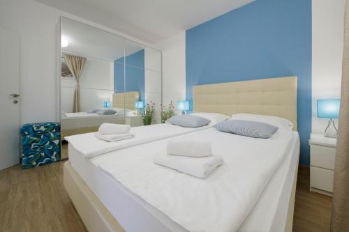 波尔Serviced Family Suite by the sea, Mezaninе lеvеl的白色的卧室配有一张白色的大床和镜子