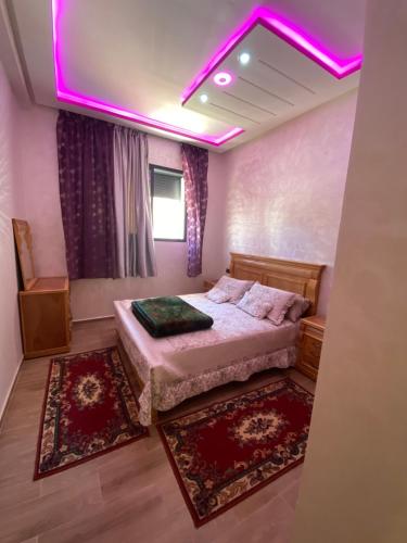 布兹尼盖Bouznika的一间卧室配有一张粉红色照明床