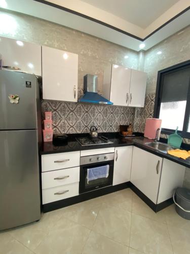 布兹尼盖Bouznika的厨房配有白色橱柜和冰箱。
