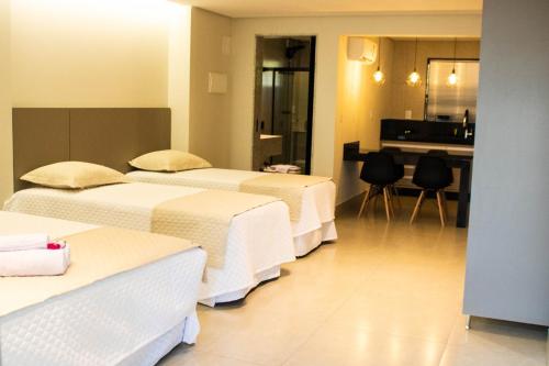 卡皮托利乌ESCARPAS FLATS的酒店客房设有三张床和厨房