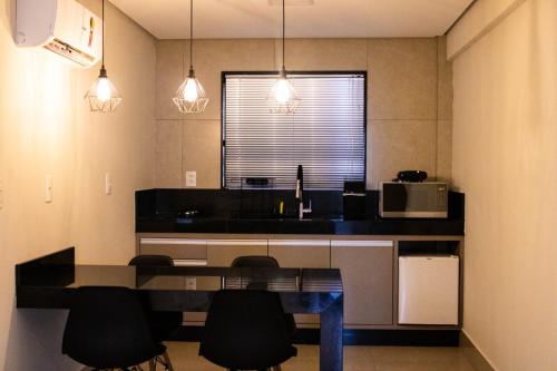 卡皮托利乌ESCARPAS FLATS的厨房配有桌椅和微波炉。