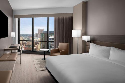 圣安东尼奥AC Hotel by Marriott San Antonio Riverwalk的酒店客房设有一张床和一个大窗户