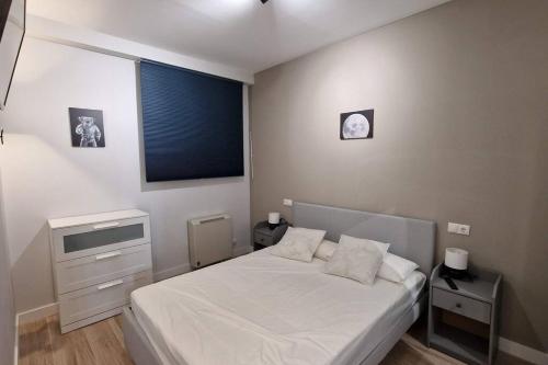 马德里Loft en Madrid junto al metro.的一间卧室配有一张带2个床头柜的大型白色床