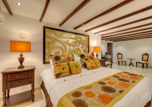 卡塔赫纳Hotel Dorado Plaza Calle del Arsenal的卧室配有一张床和一张桌子及椅子