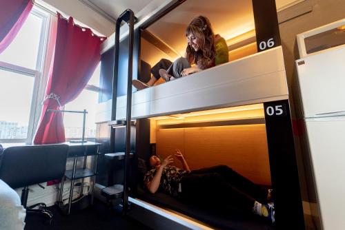 旧金山Music City Hotel - Home of the San Francisco Music Hall of Fame的躺在一张双层床上的一个女人