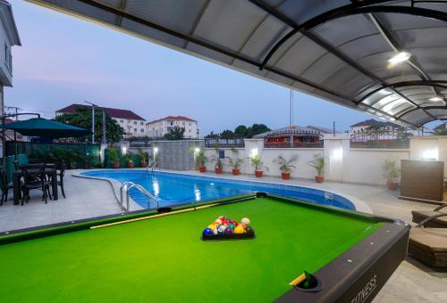 阿布贾BKT Cribs - Apartments & Suites的一个带游泳池的庭院内的台球桌