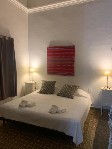 萨尔塔Casona Leguizamon的卧室配有一张带两个枕头的大白色床