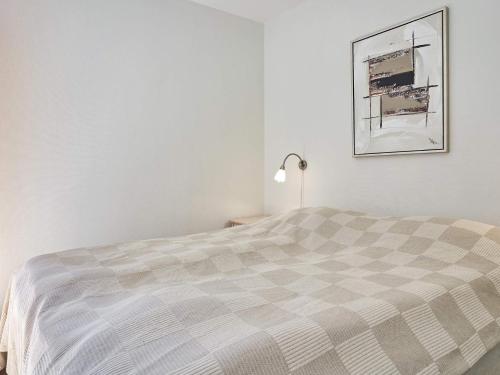 内克瑟Holiday home Nexø XLI的卧室配有一张床,墙上挂着一幅画