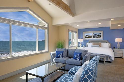 半月湾米拉马尔海滩龙柏酒店的一间卧室设有一张床和一个大窗户