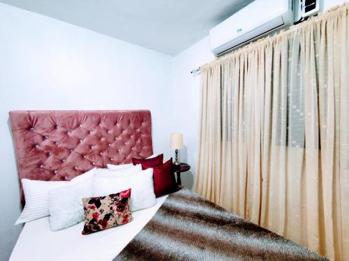 MandingaComo en Casa的一间卧室配有一张红色床头板的床